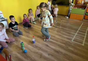 dzieci pokonują butelkowy tor przeszkód