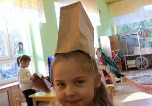 Dziewczynka w czapce wykonanej z papierowej torebki