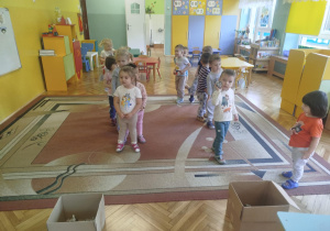 Dzieci rzucają kule z gazet do tekturowych kartonów