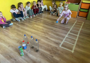 dzieci bawią się w „butelkowe kręgle”