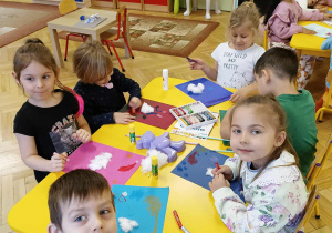 dzieci siedzą przy stoliku, wykonują pracę plastyczną - Miś