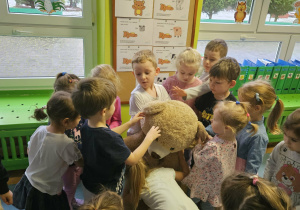 Dzieci przytulają misia