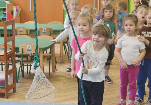dzieci wyciągają sieć z rybami przeciągając linę.