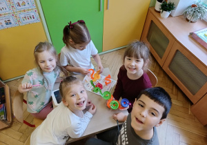 dzieci pozują do zdjęcia z prezentami od Świętego Mikołaja