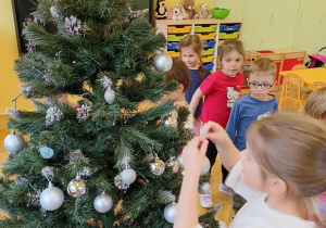 dzieci ubierają choinkę