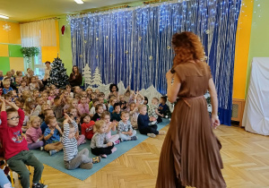 dzieci siedzą na dywanie, słuchają piosenki w języku włoskim