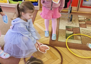 dzieci segregują odpady do kolorowych obręczy
