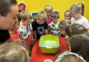 dzieci obserwują zachowanie się kuli do kąpieli w wodzie,