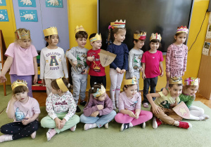 dzieci pozują do grupowego zdjęcia w wykonanych przez siebie koronach i tarczach