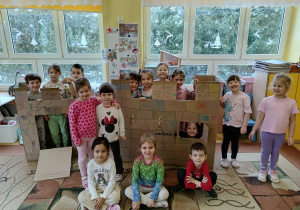 dziewczynki pozują do zdjęcia z kartonowym zamkiem