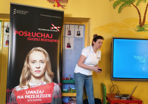 Dzieci z grupy zielonej z zaciekawieniem oglądają prezentacje dotyczącą bezpieczeństwa na przejazdach kolejowych.