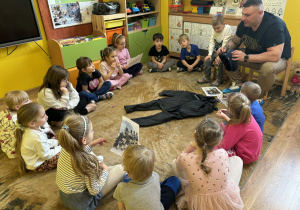 tata Tymka opowiada dzieciom o swojej pracy i pokazuje rekwizyty związane z jego pracą