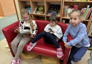 dzieci oglądają książki w bibliotece