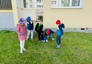 dzieci zbierają śmieci w okolicy przedszkola