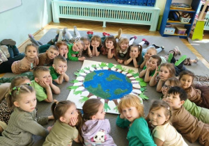 dzieci pozują do grupowego zdjęcia z wykonaną przez siebie pracą