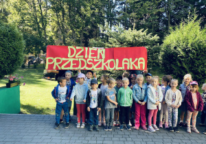 Grupa zielona pozuje do zdjęcia grupowego na tarasie przedszkolnym