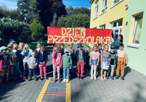 Grupa niebieska pozuje do zdjęcia grupowego na tarasie przedszkolnym