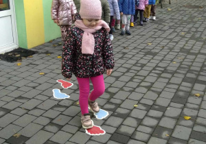 Dziewczynka przechodzi po namalowanych stopach