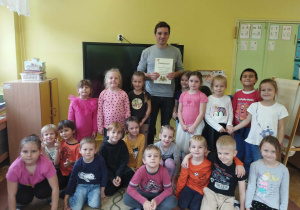 Dzieci wraz z aktorem pozują do zdjęcia grupowego