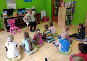 Dzieci oglądają kolekcje znaczków w klaserze.