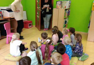 Dzieci siedzą na poduchach. Wchodzi Pan listonosz