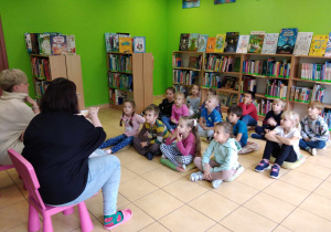 Pani siedzi na krześle, dzieci słuchają opowieści