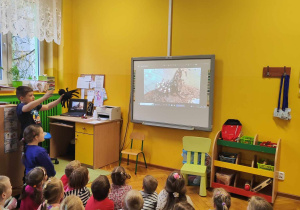 Dzieci oglądają slajd na tablicy multimedialnej.