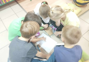 Dzieci podzielone w grupy odnajdują drogę w labiryncie.