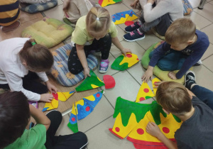 Dzieci wykonują kolejne zadanie, które polega na ułożeniu puzzli w kształcie tortu Mary Poppins.