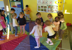 dzieci uczestniczą w zabawach z chustą animacyjną