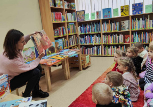 dzieci słuchają książkę " Niedźwiadek i jego sąsiedzi " czytaną przez P. Małgosię