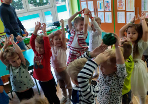 dzieci wykonują zabawy ruchowe przygotowane przez rodziców z grupy czerwonej