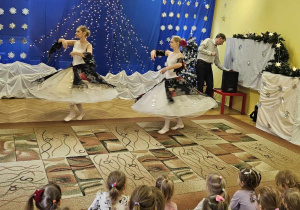 dzieci siedzą na dywanie, oglądając spotkanie baletowe