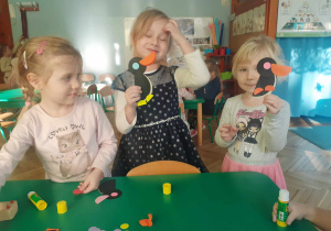 Dziewczynki prezentują pingwiny wykonane z kół origami