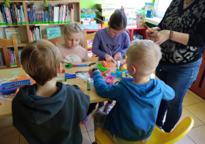 Dzieci siedzą i projektują swoją łąkę z nieużytków.