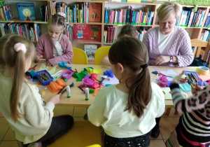 Dzieci siedzą i projektują swoją łąkę z nieużytków.