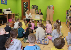 Dzieci oglądają teatrzyk kamishibai.
