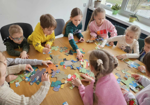 Dzieci układają puzzle w grupie