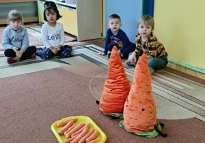 Na dywanie znajdują się pluszowe marchewki, które opowiadają ciekawostki o marchewkach
