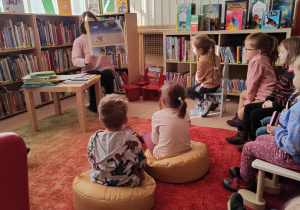 dzieci przyglądają się pokazywanej ilustracji