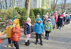 dzieci spacerują, śpiewając piosenki dla Pani Wiosny
