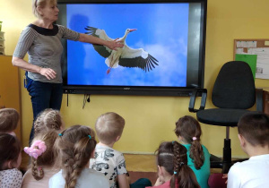 Dzieci oglądają bociana, który znajduje się na tablicy