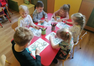 Sześcioro dzieci koloruje kolorowanki - kwiaty