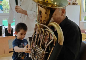 Leon próbuje grać na instrumencie dętym