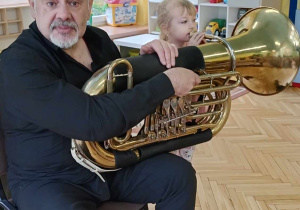 Gabrysia próbuje grać na instrumencie dętym