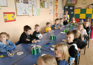 Dzieci robią żabki z rolek papierowych.