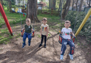 Chłopcy bujają się na huśtawkach