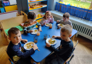 Dzieci ze smakiem zjadają hiszpańską paellę