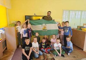 Dzieci pozują do zdjęcia grupowego wraz z naszym gościem