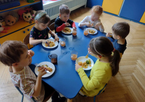 Dzieci ze smakiem zjadają hiszpańską paellę
